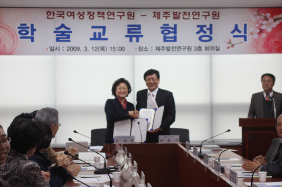 협약 체결서에 사인 후 문서를 주고받는 김태현 원장과 허향진 원장